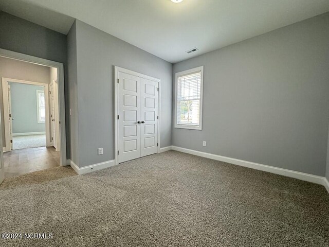 unfurnished bedroom with a closet and carpet flooring