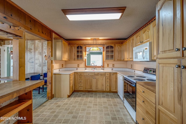 kitchen with a textured ceiling, sink, pendant lighting, and white appliances