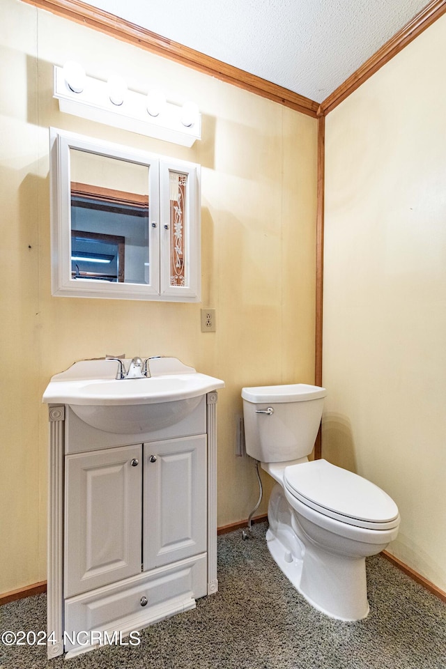 bathroom featuring vanity, toilet, a textured ceiling, and ornamental molding