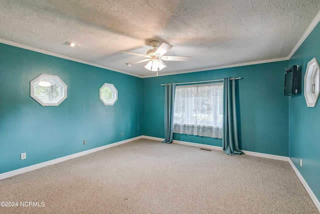 empty room with ceiling fan, a textured ceiling, carpet floors, and ornamental molding