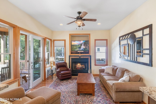 living room featuring a fireplace, hardwood / wood-style floors, and ceiling fan