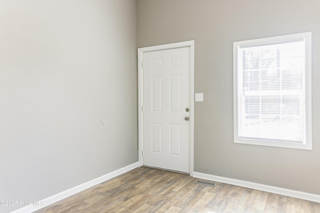 unfurnished room featuring hardwood / wood-style flooring and a wealth of natural light