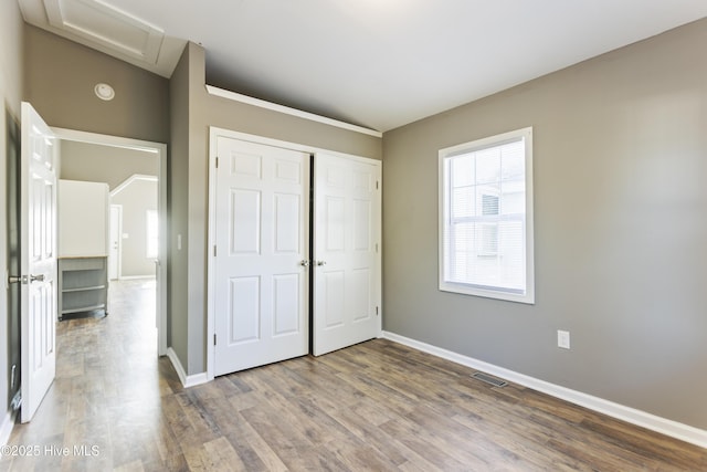 unfurnished bedroom with hardwood / wood-style floors and a closet