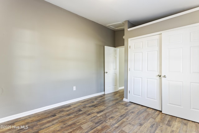 unfurnished bedroom with dark wood-type flooring and a closet