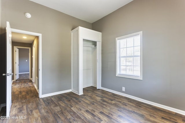 unfurnished bedroom with dark hardwood / wood-style flooring and a closet