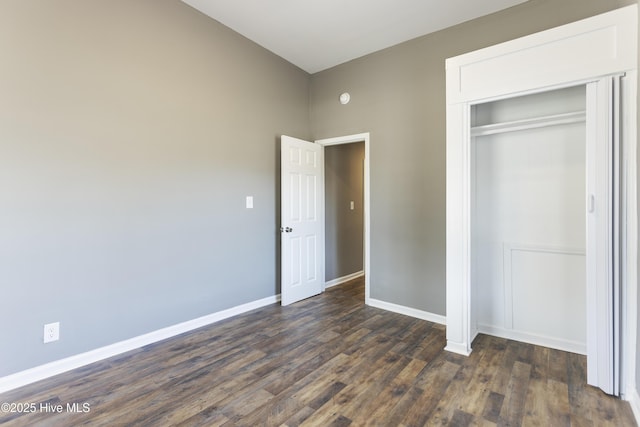 unfurnished bedroom featuring dark hardwood / wood-style floors and a closet