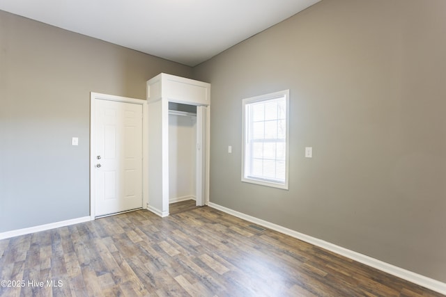 unfurnished bedroom featuring dark hardwood / wood-style flooring and a closet