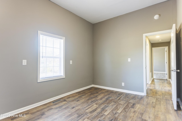 unfurnished room with hardwood / wood-style flooring