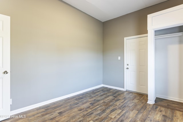 unfurnished bedroom featuring a closet and dark hardwood / wood-style floors