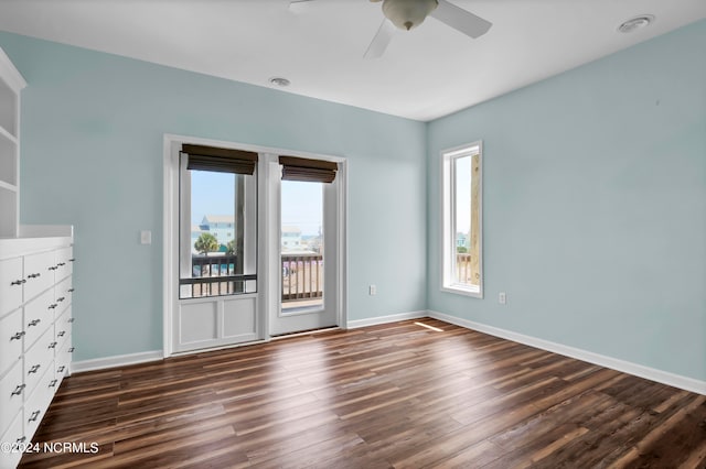 unfurnished room with ceiling fan with notable chandelier and dark wood-type flooring