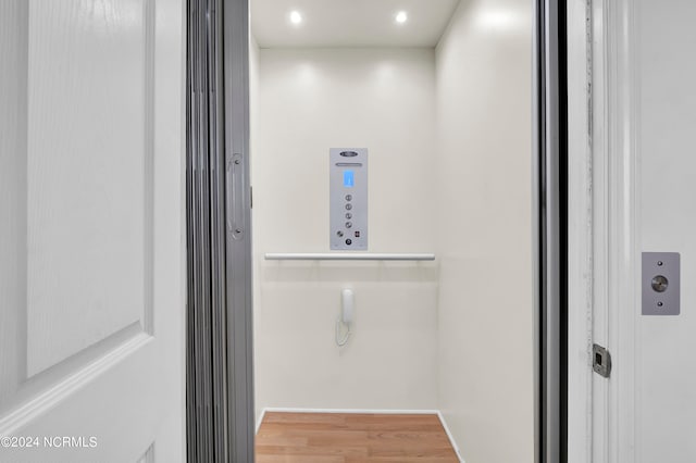 walk in closet featuring wood-type flooring and elevator