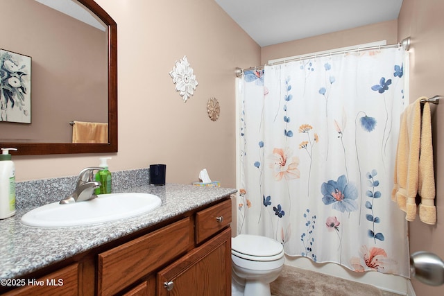 bathroom featuring vanity, shower / bath combination with curtain, and toilet