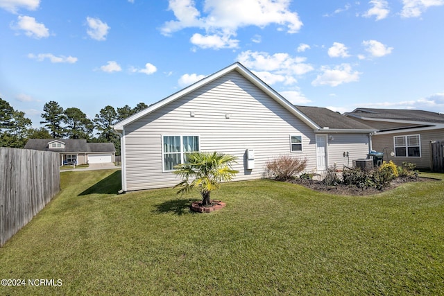 back of house featuring a yard and fence