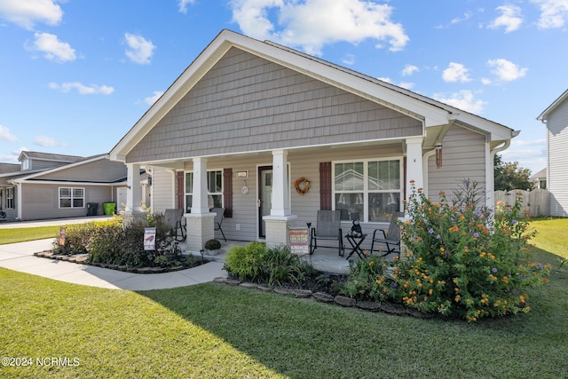 bungalow with a porch and a front lawn