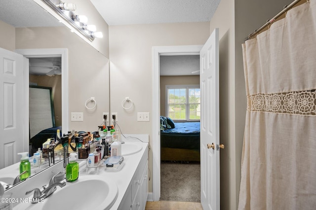 bathroom with tile patterned flooring, a textured ceiling, and vanity