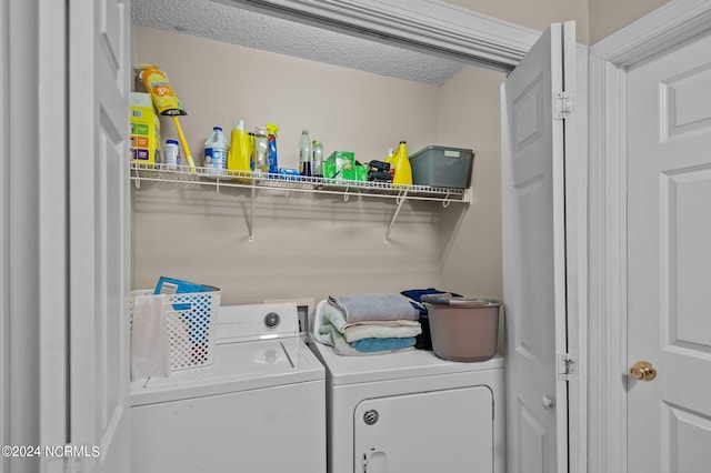 laundry room featuring a textured ceiling and washing machine and dryer