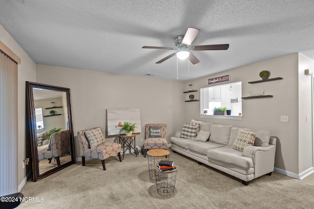 carpeted living room featuring ceiling fan and a textured ceiling