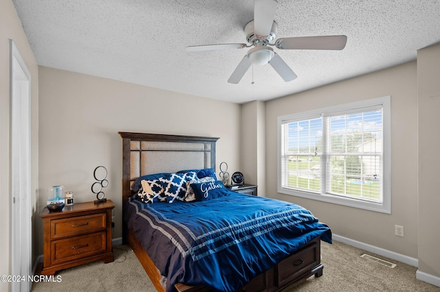 carpeted bedroom with ceiling fan and a textured ceiling