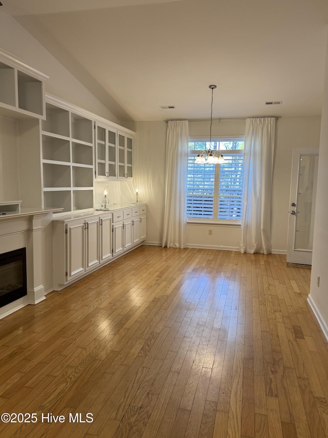 unfurnished dining area with light hardwood / wood-style floors and a chandelier