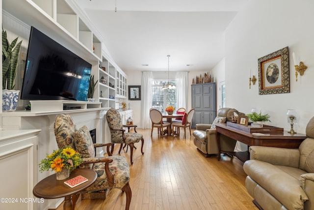 living room with an inviting chandelier and light hardwood / wood-style floors