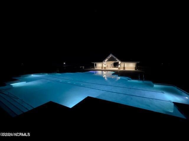 view of pool at twilight