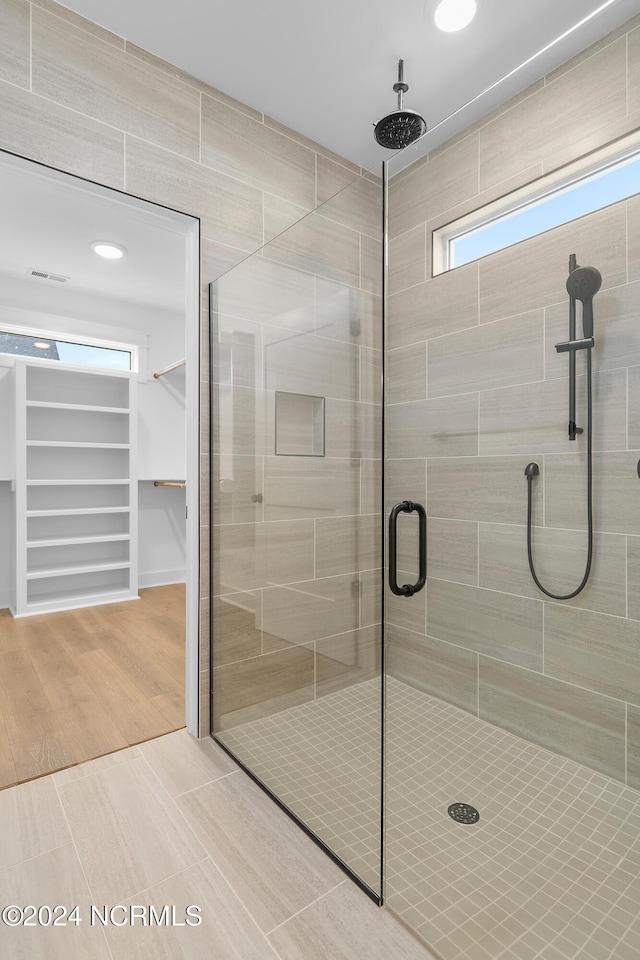 bathroom with a shower with door and hardwood / wood-style flooring