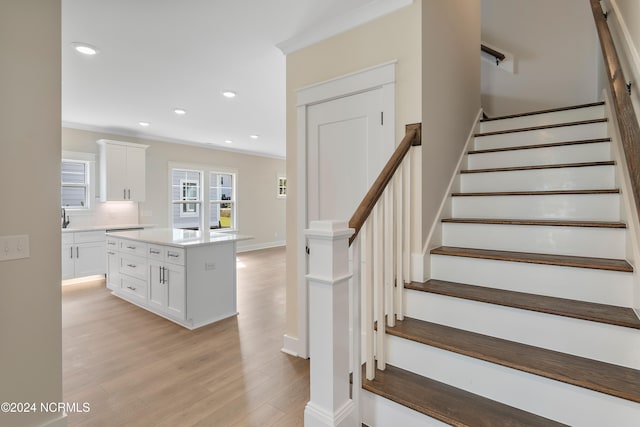 staircase with crown molding and hardwood / wood-style flooring