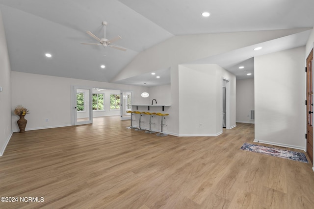 unfurnished living room with sink, ceiling fan, lofted ceiling, and light wood-type flooring