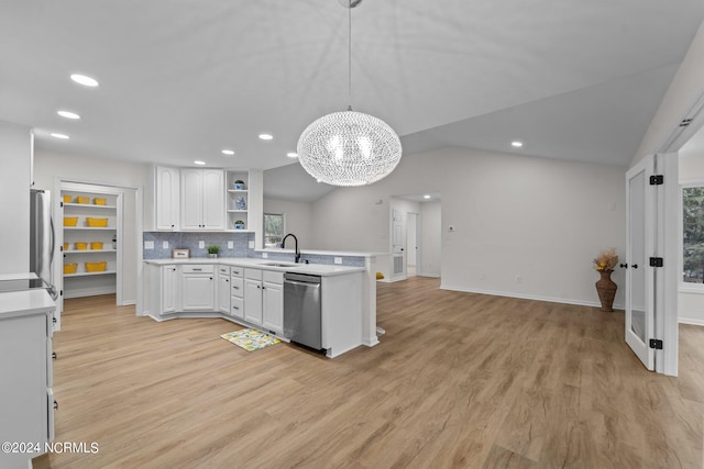 kitchen featuring sink, hanging light fixtures, stainless steel appliances, lofted ceiling, and white cabinets