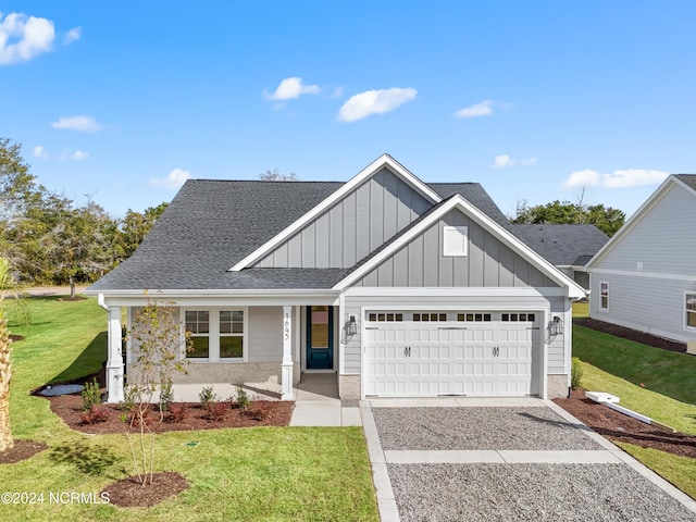 view of front facade with board and batten siding, a shingled roof, a garage, a front lawn, and concrete driveway