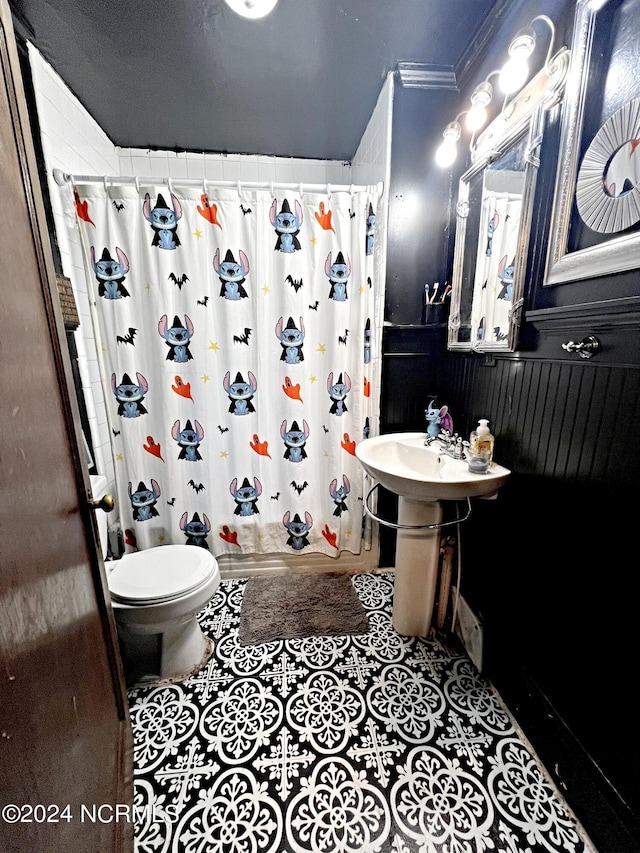 bathroom featuring a textured ceiling, crown molding, toilet, and a shower with curtain