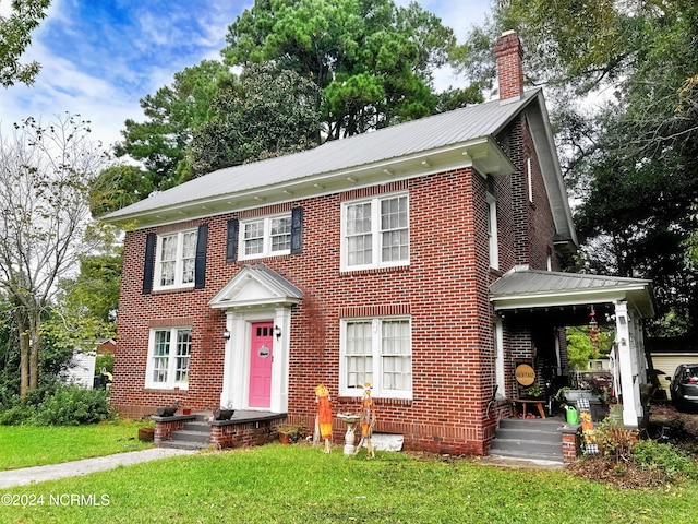 colonial-style house featuring a front lawn