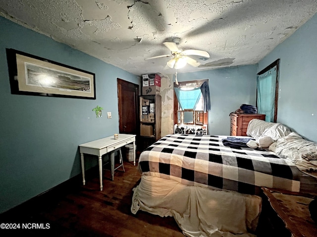 bedroom with ceiling fan, a textured ceiling, and dark wood-type flooring