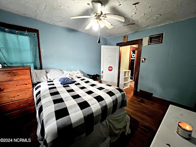 bedroom featuring ceiling fan, dark hardwood / wood-style floors, and a textured ceiling