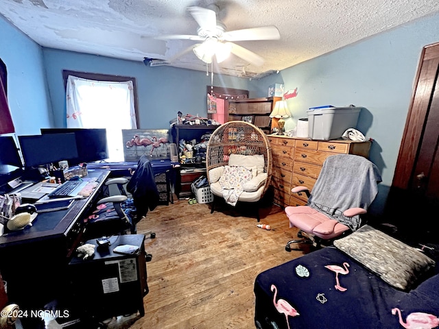 bedroom with a textured ceiling, hardwood / wood-style floors, and ceiling fan