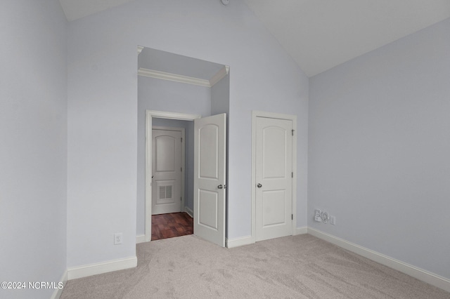 unfurnished bedroom with light carpet, vaulted ceiling, and crown molding