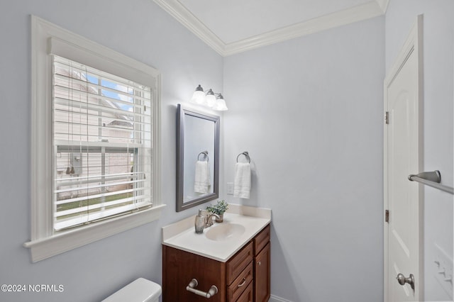 bathroom with ornamental molding, vanity, toilet, and plenty of natural light