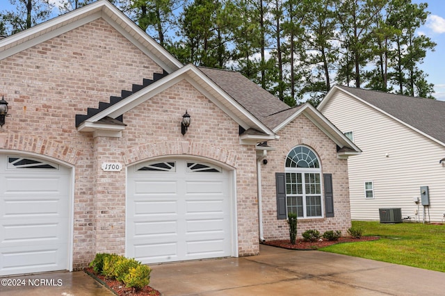 view of front of home featuring a garage and central air condition unit