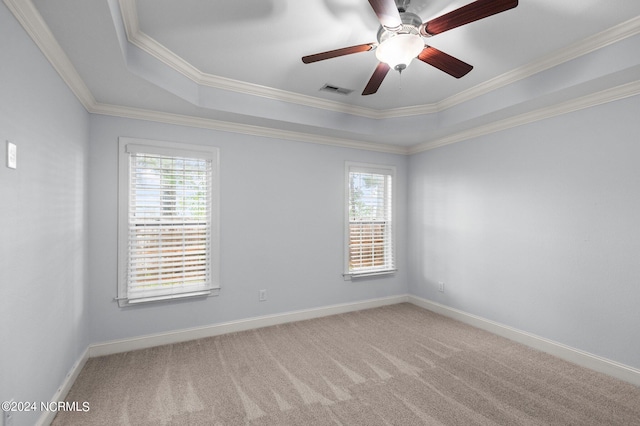 carpeted empty room with ceiling fan, a raised ceiling, and crown molding