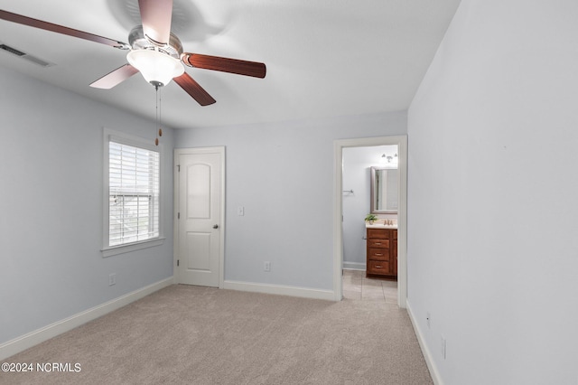 unfurnished bedroom with ceiling fan, connected bathroom, and light carpet