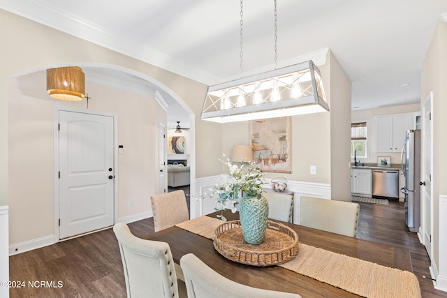 dining space with sink, dark hardwood / wood-style floors, and ornamental molding