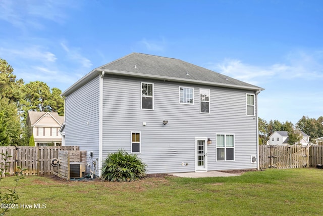 back of property with a lawn, central air condition unit, and a patio