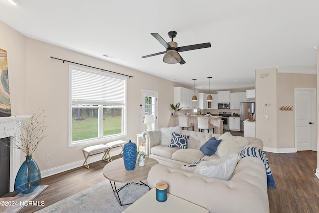 living room with dark hardwood / wood-style floors, ceiling fan, and a fireplace