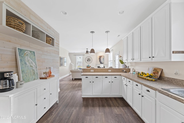 kitchen with white cabinets, hanging light fixtures, ceiling fan, dark hardwood / wood-style flooring, and kitchen peninsula