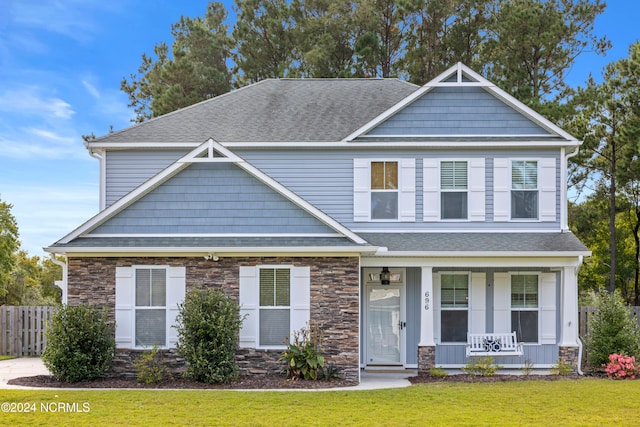 craftsman inspired home with covered porch and a front yard