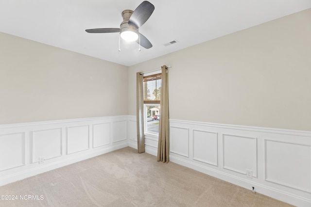 unfurnished room with light colored carpet and ceiling fan