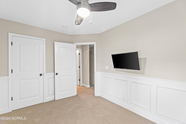 unfurnished bedroom featuring ceiling fan, a closet, and light carpet