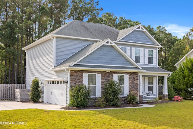 craftsman inspired home with a front lawn, covered porch, and a garage