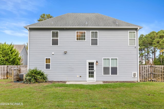 back of house featuring a yard and central air condition unit