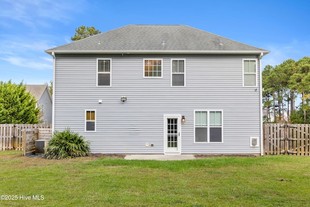 back of property with central AC and a yard